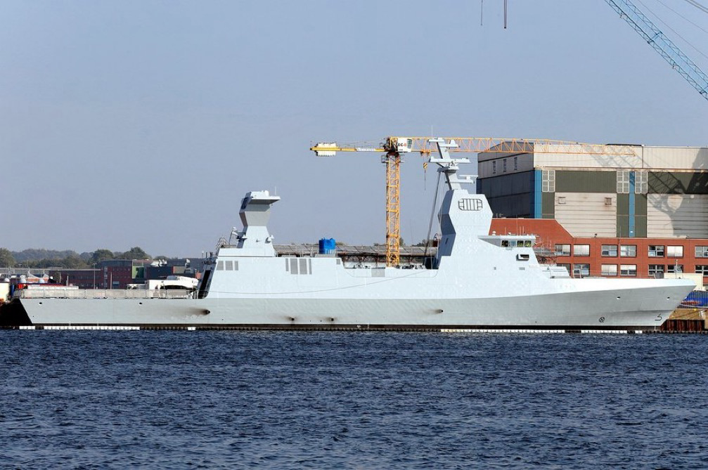 Israeli Naval Service Sa'ar 6 corvette warships seen docked at a ThyssenKrupp Marine Systems (TKMS) dock in Kiel, Germany (L) and firing bombs while at sea (R). Photo credits: Marco Kuntzsch/Wikimedia Commons (L) and IDF Spokesperson Unit (R)