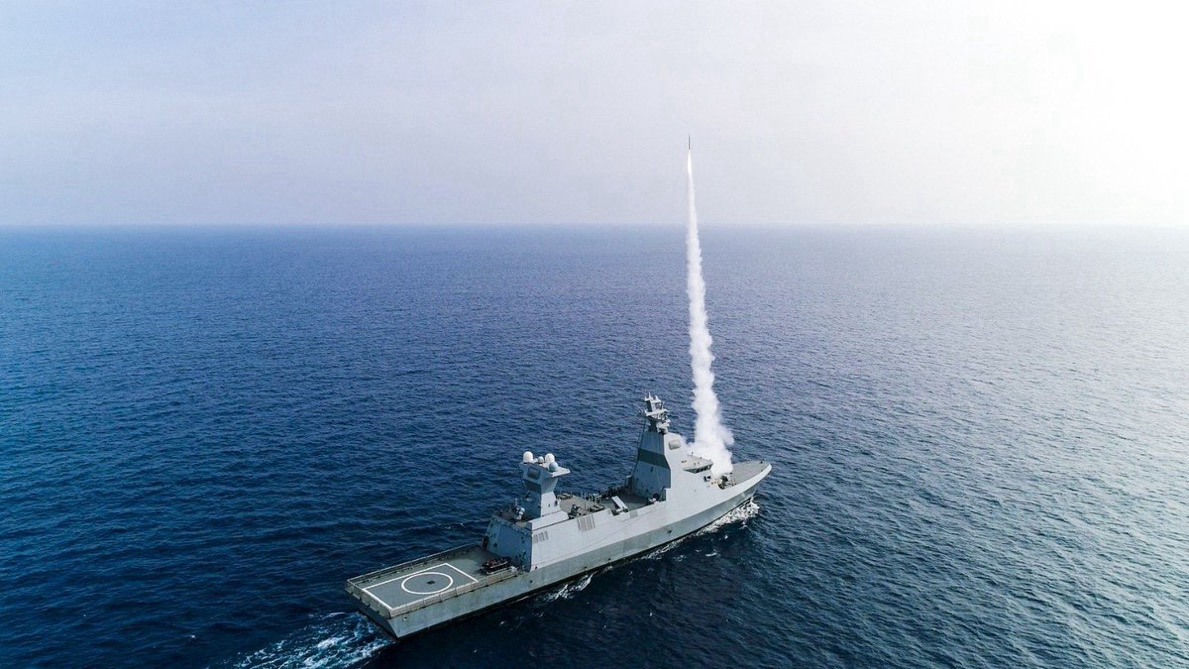 Israeli Naval Service Sa'ar 6 corvette warships seen docked at a ThyssenKrupp Marine Systems (TKMS) dock in Kiel, Germany (L) and firing bombs while at sea (R). Photo credits: Marco Kuntzsch/Wikimedia Commons (L) and IDF Spokesperson Unit (R)