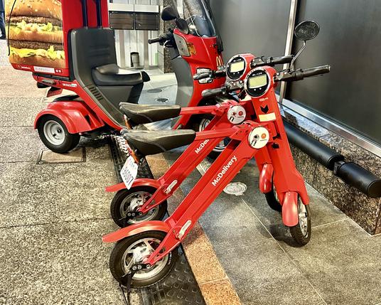 Rote, kleine Roller für Auslieferatoren vor dem McDoof