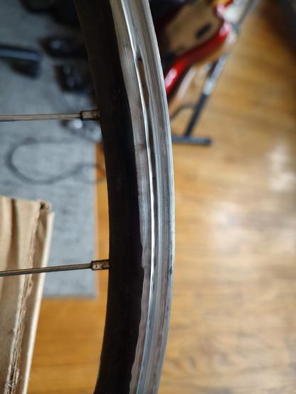 A closeup of a severely warn and damaged bicycle rim