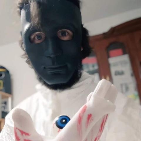 Yo disfrazado del Sacaojos con una careta negra, un mono de vestir blanco y un ojo de mentira en la mano.