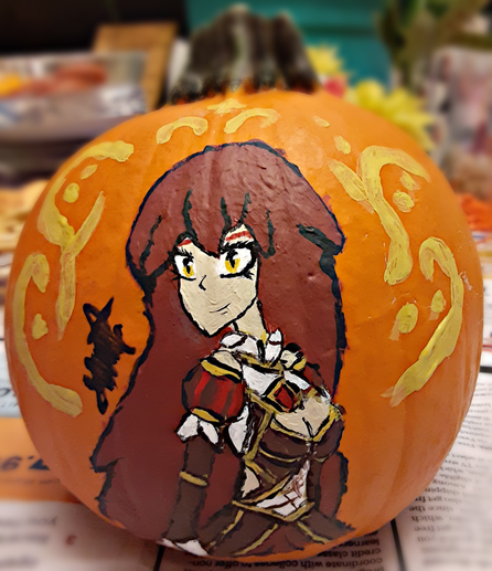 A painting of Eden on a small orange pumpkin with a thick, dark green stem.
Eden is a young woman with long maroon hair and gold eyes; she wears a brown dress trimmed with gold and a red gem resting on her chest. She smiles gently while staring at the viewer.
Surrounding Eden are golden swirls and dots, as if she were blessed by Apollo.
Although blurry, the viewer can make out crackers, salomi and cheese slices sitting on top of a closed black laptop, a couple of pictures in frames, a green plant, yellow and orange streamers, the turquoise wall and the stairway, and the newspaper used to keep stray paint off the table.