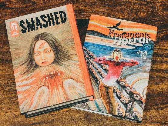 two junji ito books on a table, the covers of the books showing weird body-horror-esque imagery