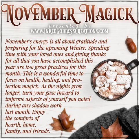 Fall leaves and acorns surround a cup of hot cocoa and a grey knit scarf, all arranged on a white wood surface. The text describes what sort of magickal energy you can expect for the month of November and how to utilize it. Presented by Inked Goddess Creations.