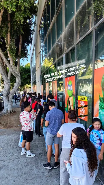 Photo of a long line of Angelenos at Spirit Halloween on La Brea procrastinating with their Halloween costume purchases.