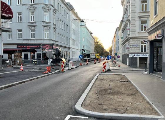 Davidgasse in Favoriten, auf der linken Seite der in Bau befindliche getrennte neue Radweg und einige Baumaschinen, auf der rechten Seite ein neu angelegtes Beet für Begrünung