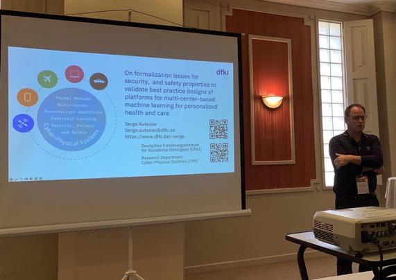 The image shows a presentation slide focusing on formalization issues related to security, privacy, and safety in cyber-physical systems, specifically for multi-center-based machine learning in health and care. Speaker identified as Serge Autexier.