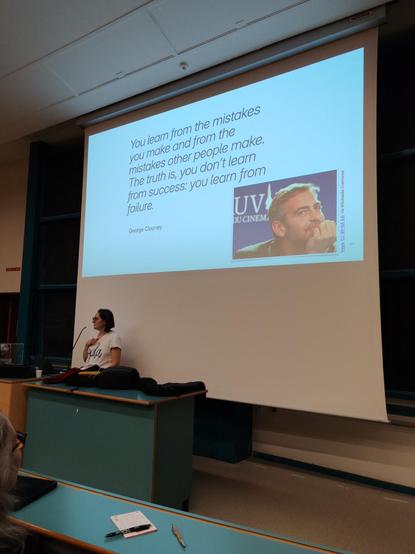 Agnès HASSER qui présente une slide de sa présentation avec la citation: "You learn from the mistakes other people make. The truth is, you don't learn from success: you learn from failure" - Georges Clooney avec une image de Georges Clooney en bas de la slide.