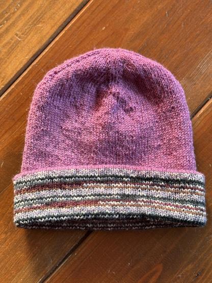 Same purple hand knitted hat but now with the green, brown and light purple striped inside folded to the outside so it has a striped brim 