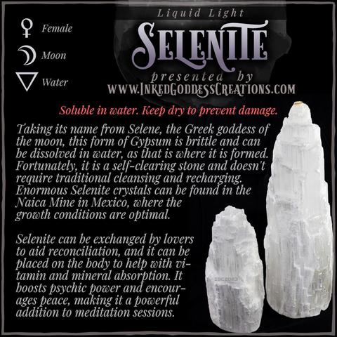 Two selenite towers, one about half the size of the other, sit against a black background. The text explains selenite's metaphysical correspondences, some trivia about it, and ways to use it in your magickal practice. Presented by Inked Goddess Creations.