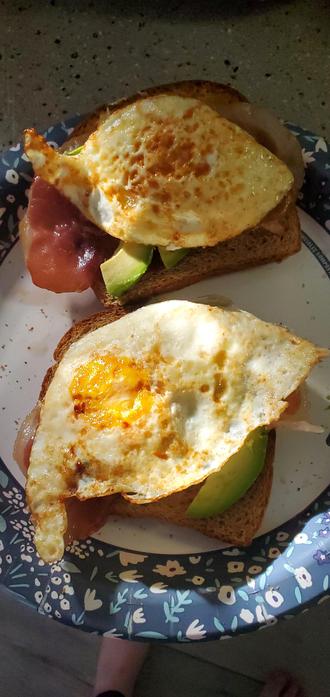 Picture of toast with over medium eggs, prosciutto, and avocado