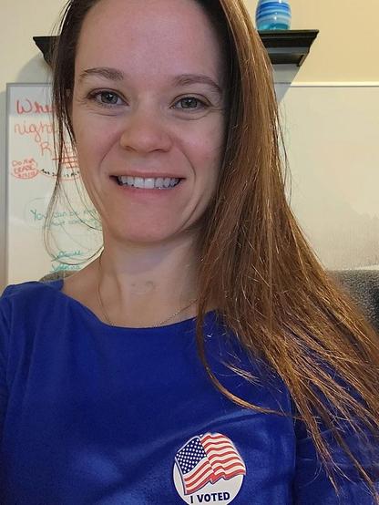 Selfie of a woman with long brown hair and an "I voted" sticker