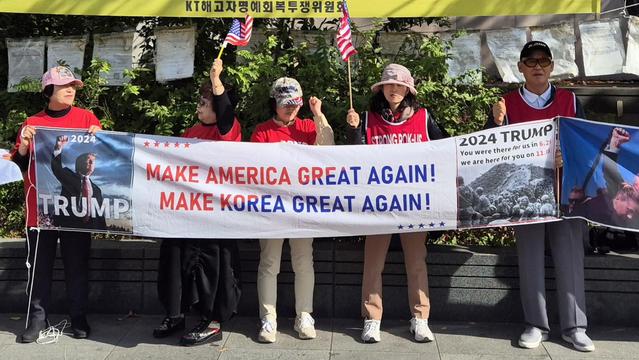 Korean pro-Trump protesters at Gwanghwamun Square in Seoul hold up a banner that reads 'Make America Great Again! Make Korea Great Again!' at the center. On the left side of the banner is a photo of Donald Trump, on the right a photo of US combat troops of the 187th Airborne Infantry Regiment taken in May 1951, during the Korean War. Above that photo it says 'You were there for us in [sic] 6.25, we are here for you on 11.05,' referring to the dates of the outbreak of the Korean War in 1950 and the 2024 US presidential election, respectively. 