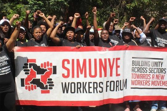 Banner:
SIMUNYE Workers Forum 
Building Unity 
Across Sectors
Towards a new 
Workers Movement 

Members wearing union shirts raise their arms high and give clenched “solidarity” fist 