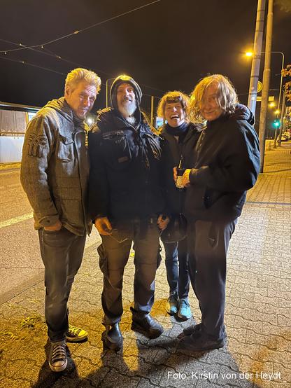 Die Band 375 CEG . Drei Männer, eine Frau. Sie stehen nachts an einer beleuchteten Straße. Es scheint kalt zu sein, sie tragen dicke Jacken. Sie lachen. Einer schaut etwas skeptisch. Das Foto wurde von Kirstin von der Heydt aufgenommen.