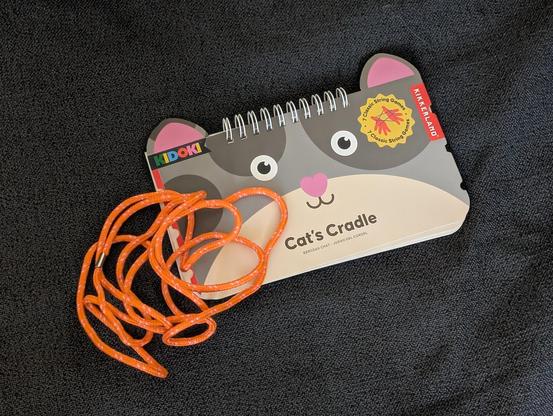 A Cat's Cradle booklet and the accompanying loop of string.