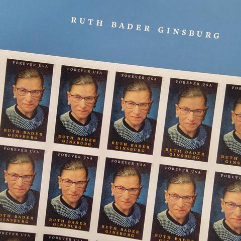 Close up of a sheet of USPS "Forever" stamps featuring a picture of Supreme Court Justice Ruth Bader Ginsburg.