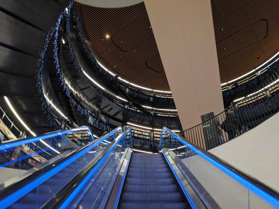 internal view up an escalator of Birmingham Central Library

blue lights against the dark make it look futuristic