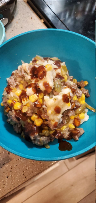 Picture of a bowl filled with meat, veggies, mashed potatoes, and cheese.
