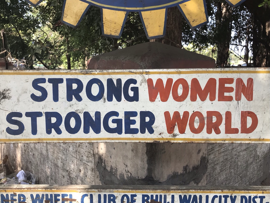 Das Foto zeigt ein Schild mit der Aufschrift: Strong Women, Stronger World
