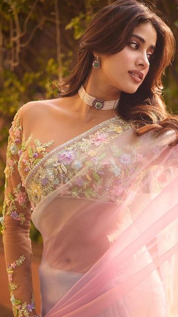 Janhvi Kapoor stuns in a romantic pink ombre saree by Manish Malhotra, adorned with intricate floral patterns that celebrate femininity and style. With an enchanting design that flows effortlessly, this look encapsulates Janhvi's elegance and showcases her as a true fashion trendsetter. Be captivated by Janhvi's beautiful outfit choice, and find your fashion inspiration in her unforgettable, timeless look!