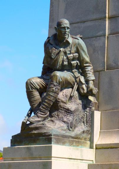 A bronze statue of a soldier, seated in uniform, is a detail from the St Annes-on-the-Sea War Memorial. The soldier is depicted wearing detailed military attire, including ammunition pouches, and boots. The statue is mounted on a stone pedestal with a clear blue sky in the background.

This statue is a poignant tribute to those who served. The sculptor has captured the “Thousand yard stare”  of a soldier who has been in the trenches perfectly.