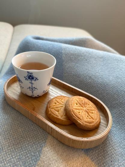 Shortbread auf einem Holztablet mit einer Tasse Tee