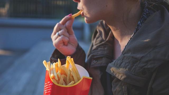 Person eating french fries.