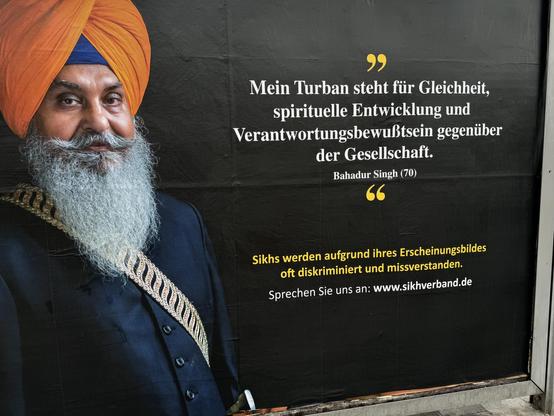 Großes Plakat in Berlin: „Mein Turban steht für Gleichheit, spirituelle Entwicklung & Verantwortungsbewußtsein gegenüber
der Gesellschaft.“ Bahadur Singh (70) - Sikhs werden aufgrund ihres Erscheinungsbildes oft diskriminiert & missverstanden.