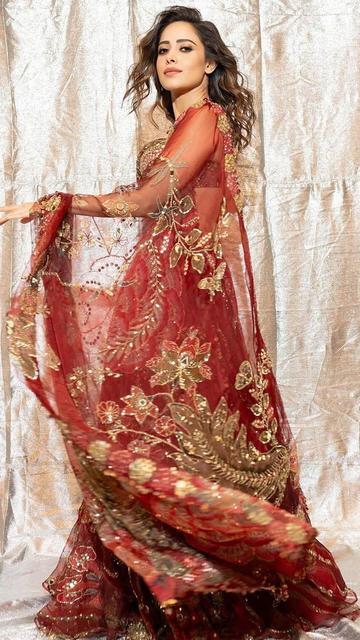 Nushrratt Bharuccha stuns in a vibrant red lehenga designed for those who appreciate detailed craftsmanship and elegance. Ideal for weddings or festive celebrations, her look is a true testament to timeless fashion. Take notes from her stunning ensemble today!