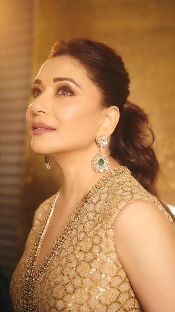 In a golden Tarun Tahiliani designer gown, Madhuri Dixit radiates glamour and grace. This exquisite creation, adorned with intricate embellishments, highlights her timeless beauty. The dazzling gown is a perfect representation of elegance, making it a standout choice for red carpets and special events.