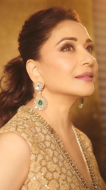 Madhuri Dixit makes a statement in a shimmering golden gown by Tarun Tahiliani. The designer's exquisite attention to detail and Madhuri’s graceful aura create a mesmerizing blend of modernity and tradition in this fashion masterpiece.