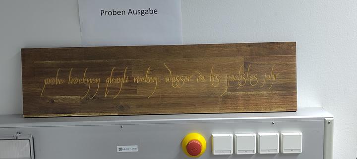 A dark wooden sign labeled in Elven script with the German text: "Probe trocknen Quanti rocken. Wasser da bis nächstes Jahr." Translation: "Dry sample, rock the Quanti lab. If there is still water we will see you again next year."