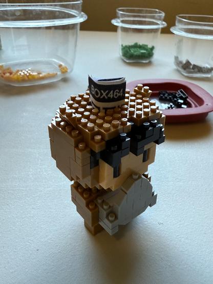 The same small Lego figure, showing the qrcode being stuffed into the “brain”.