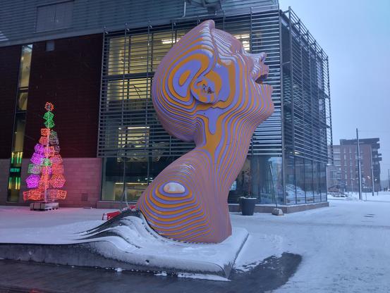 Ihmisen päätä muistuttava värillisistä levyistä tehty veistos Redin edustalla, kuvattu sivusta.