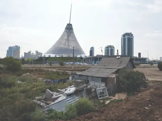 Astana’s Khan Shatyr mall, designed by renowned British architect Norman Foster, towers over a more ramshackle building. 

Photo: Nick Hannes/Panos