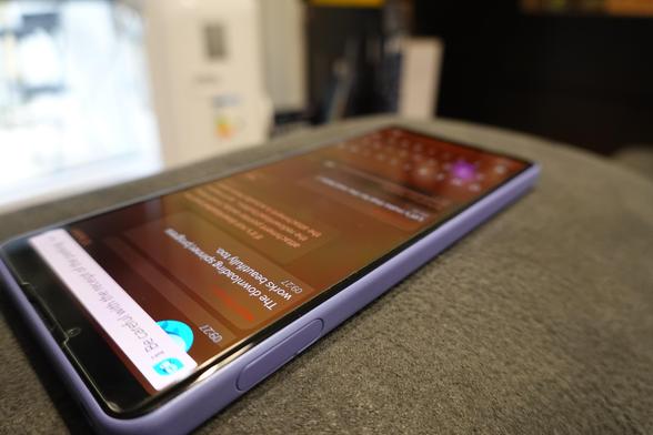 An Xperia 10 IV showing Whisperfish running on Sailfish OS. The focus of the image is a message from @direc85, Matti Viljanen, that says "The downloading spinner/progress work beautifully too", suggesting that this is a discussion group among Whisperfish developers.