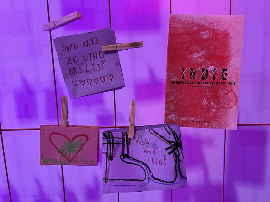 four zines randomly hung up with clothes pins. one more professional looking one is titled “indie” with each letter scratched out. it is about the ideological theft of the word.