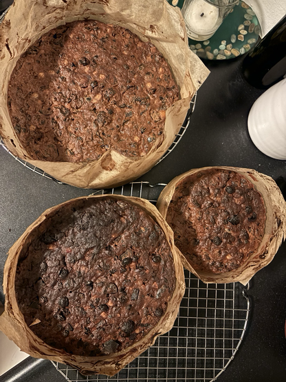 Overhead photo of three round fruit cakes in varying sizes still in their baking paper.