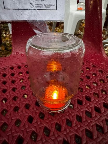 Eine orangene LED unter einem Glas auf einem Stuhl.