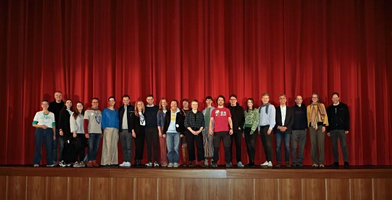 A group of people in front of red curtains in a cinema