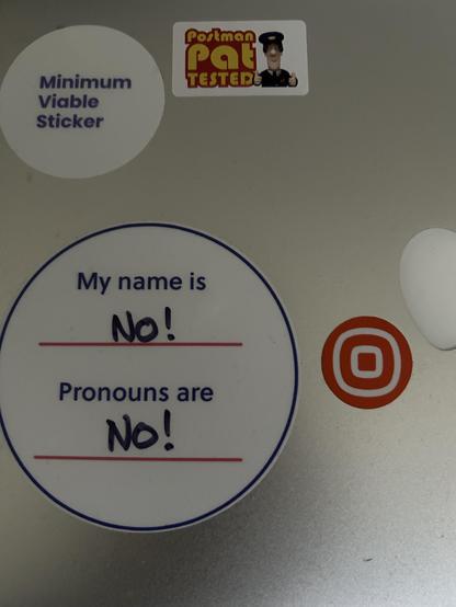 A laptop with stickers one of which says “My name is No!, Prounouns are No!”