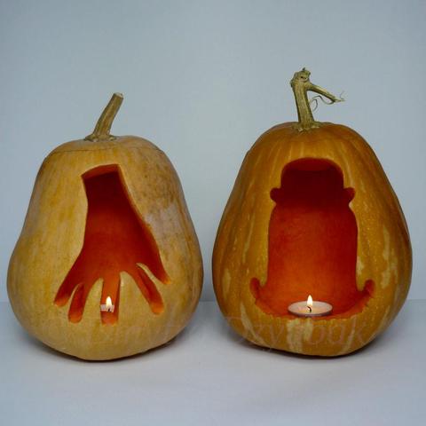 Thing T. Thing and Cousin Itt from The Addams Family are depicted on two carved pumpkins. Pumpkins contain tealight candles inside.