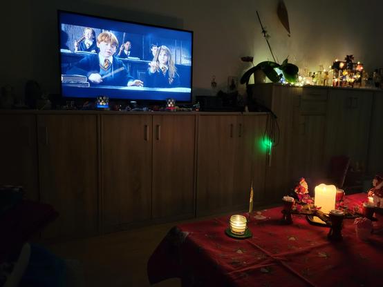 Fernseher mit Harry Potter und der Stein der Weisen.
Kerzenschein der Weihnachtsdeko. 