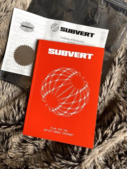 A red booklet from Subvert cooperative, titled plan for the artist-owned internet, resting on a black and white embossed membership certificate. There is brown fake fur in the background 