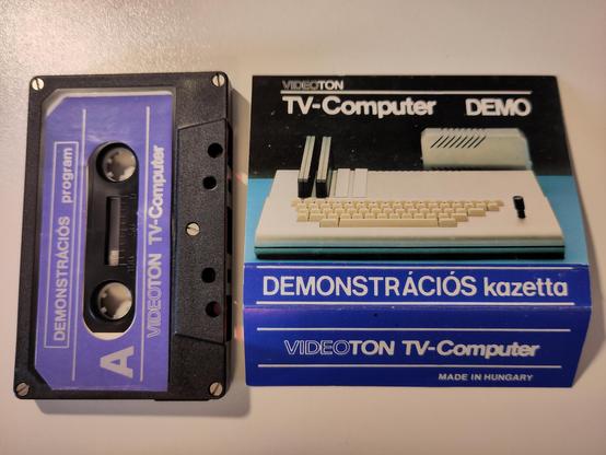 The label and the cassette removed from the case. The A side of the cassette is blue, and says "DEMONSTRÁCIÓS program". The tail end of the label says "VIDEOTON TV-Computer, Made in Hungary".
