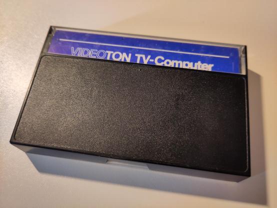 Back side of the case tape. It's black, with a blue part of the label that says "VIDEOTON TV-Computer" visible.