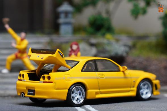 A right side of Nissan Skyline GT-R (R33) Nismo 400R Yellow by Pop Race in 1:64 scale with 1:64 figures on AREA 164