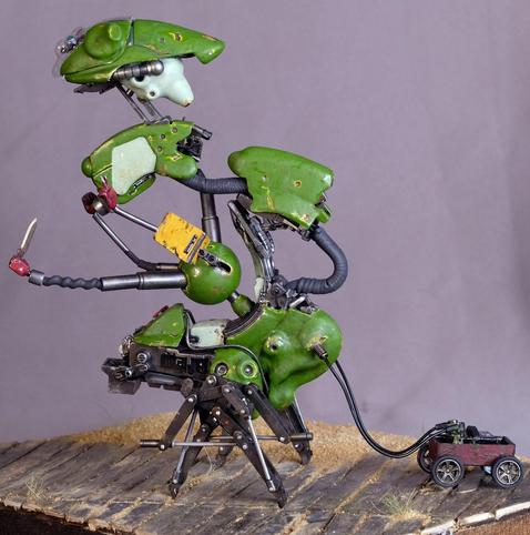 An oddly shaped green robot with 4 hands and crab legs. Each hand has either a rock, paper, scissors fist, or a knife.