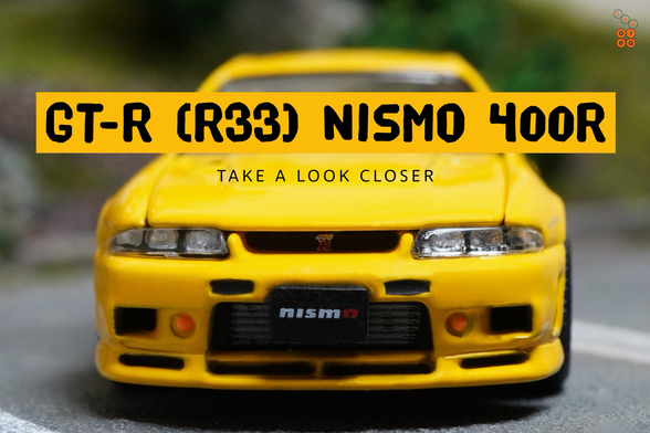 A close-up shot of Nissan Skyline GT-R (R33) Nismo 400R Yellow by Pop Race in 1:64 scale with 1:64 figures on AREA 164